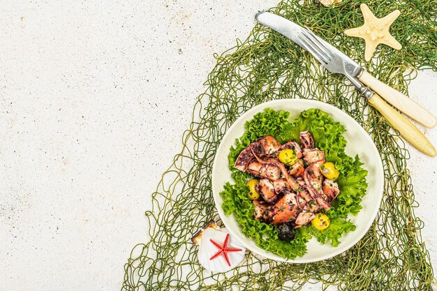 Salada de polvo com alface, azeitonas e especiarias numa tigela Decoração marinha de frutos do mar frescos e saudáveis