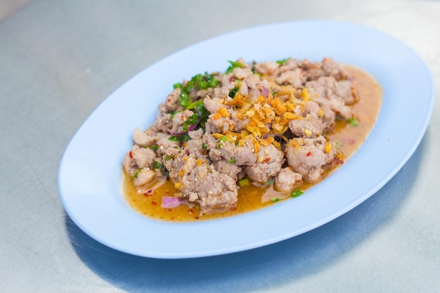 Salada de porco picada picante é comida tradicional do nordeste da Tailândia Contém carne de porco picada assada