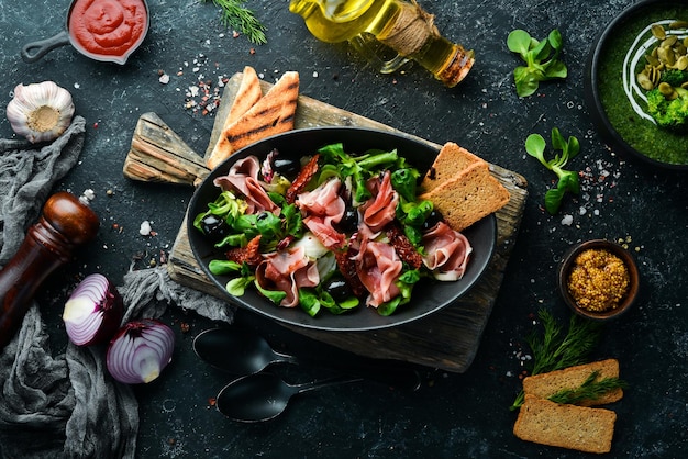 Salada de presunto com azeitonas em uma tigela preta Cozinha espanhola Vista superior Espaço livre para o seu texto Estilo rústico