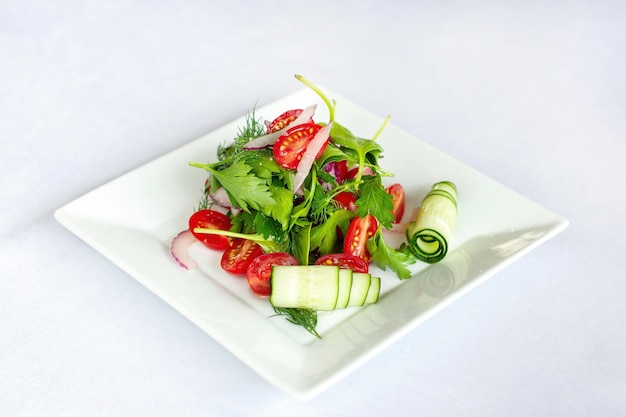 Salada de primavera com rabanetes, pepinos e tomate Em um prato polvilhado com sal Composição diagonal