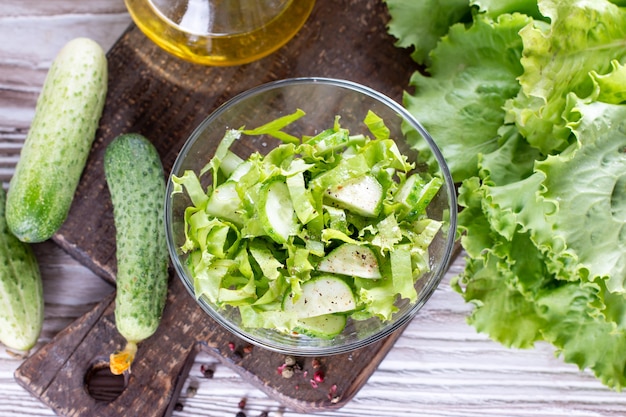 Salada de primavera desintoxicante de vegetais verdes (repolho, pepino, cebola verde e salsa) em um prato. Vista superior.