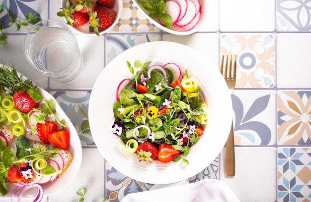 Salada de primavera verão com flores comestíveis pansy viola e microgreens frescos e morangos