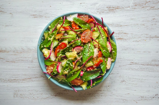 Salada de quinoa com folhas verdes e legumes. Prato vegetariano magra.