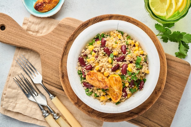 Salada de quinoa de milho feijão preto mexicano com limão caramelizado em uma tigela de barro vintage velha sobre um fundo de concreto cinza claro. Prato da cozinha tradicional mexicana. Vista superior, simulação.