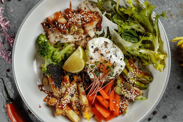 Salada de quinoa de tigela saudável com abacate de atum brócolis na mesa rústica de madeira vista superior