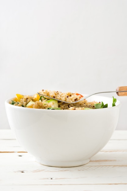 Foto salada de quinoa em tigela na mesa de madeira branca