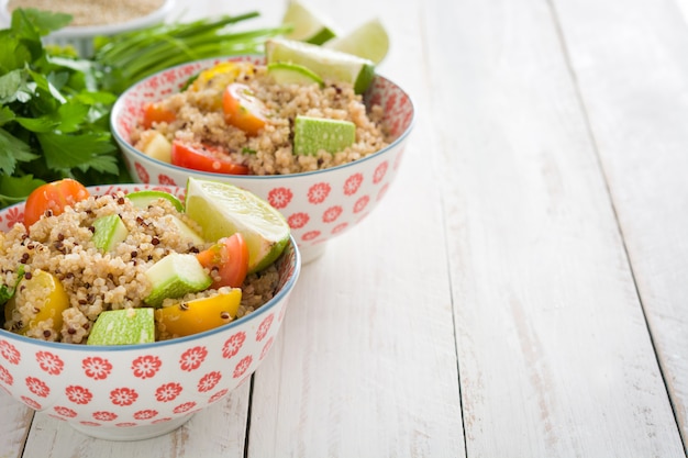 Salada de quinoa em tigela na mesa de madeira branca