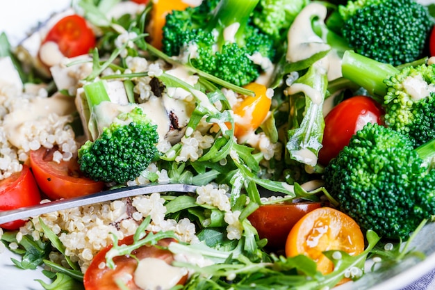 Salada de quinoa vegana com tofu, brócolis e tomate. Conceito de comida saudável.