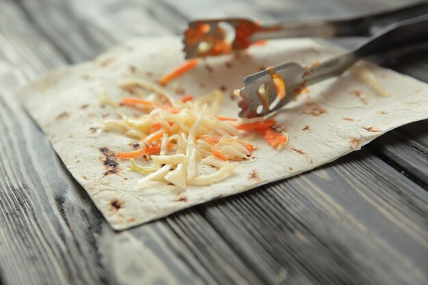 Salada de repolho em lavash em fundo de madeiraphoto com spa de cópia