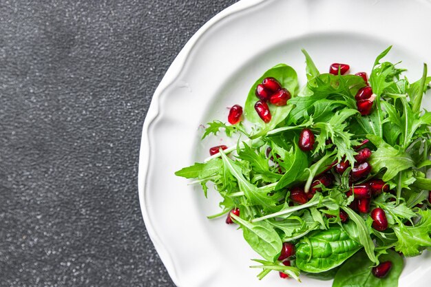 salada de romã folhas verdes, semente de romã, mistura de alface comida saudável refeição lanche na mesa