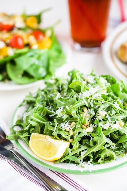 Salada de rúcula com pinhões no prato em restaurante italiano.