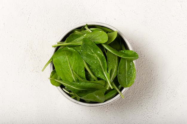 Salada de rúcula em uma tigela no fundo branco