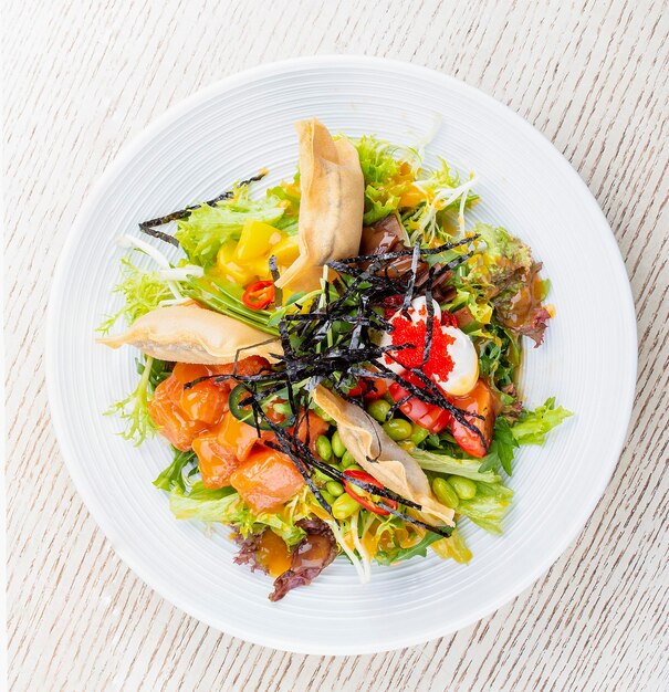 Salada de salmão com queijo creme de abóbora em conserva feijão daikon tobiko caviar e molho de manga e pimenta prato PanAsiático