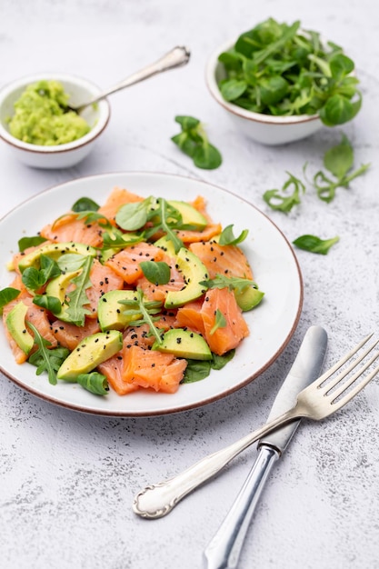 Salada de salmão fresco com abacate, para dieta cetogênica e baixa em carboidratos. Fundo enferrujado, vista superior, copie o espaço.