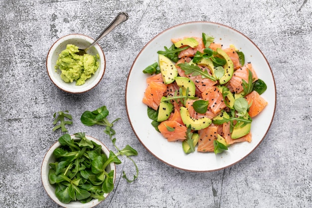 Salada de salmão fresco com abacate, para dieta cetogênica e baixa em carboidratos. Fundo enferrujado, vista superior, copie o espaço.