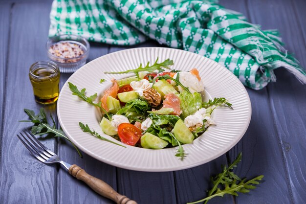 Salada de salmão fresco com tomate vermelho, queijo macio, pepino, nozes e rúcula