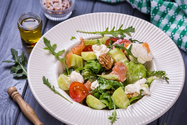 Salada de salmão fresco com tomate vermelho, queijo macio, pepino, nozes e rúcula