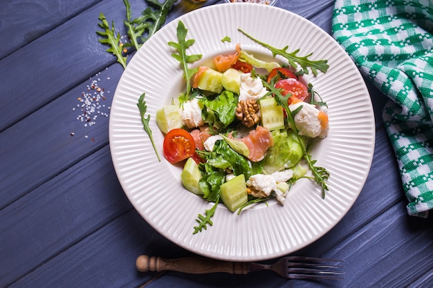 Salada de salmão fresco com tomate vermelho, queijo macio, pepino, nozes e rúcula