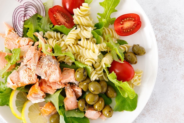 Salada de salmão grelhado com alface fresca, tomate, azeitonas verdes, cebola roxa e macarrão Dieta alimentar saudável Vista superior