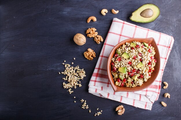 Salada de sementes germinadas de trigo, abacate, nozes e romã em placa de argila