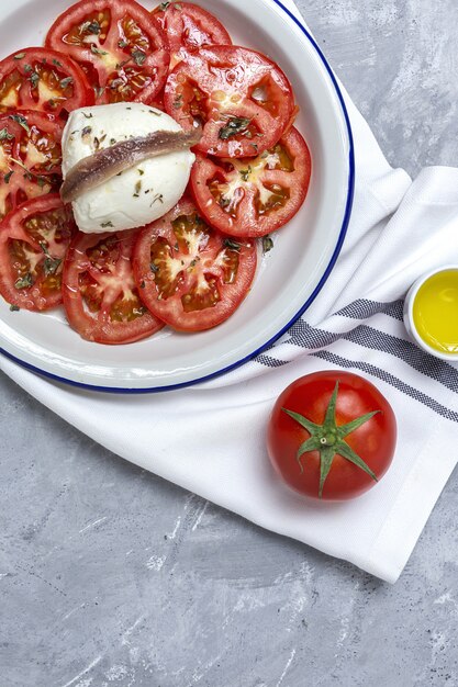 Salada de tomate caseiro saudável com mussarela, anchovas e orégano