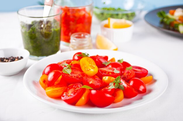 Salada de tomate cereja fresco com manjericão na mesa de jantar