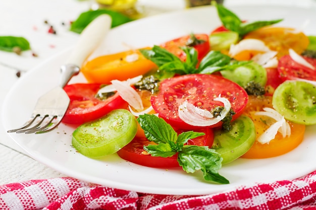 Salada de tomate colorido com pesto de cebola e manjericão.