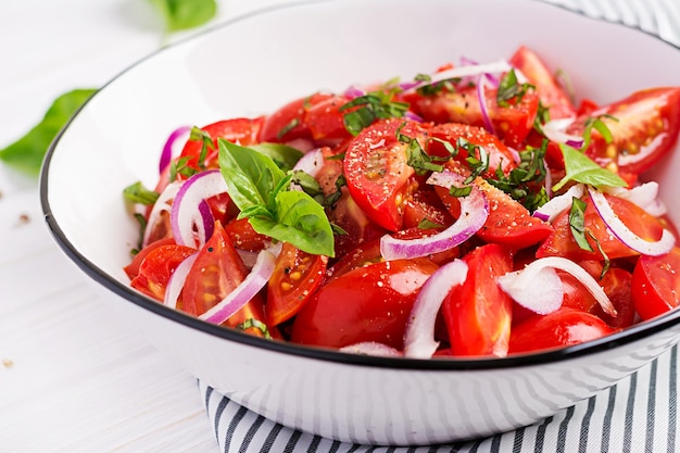 Salada de tomate com manjericão e cebolas vermelhas Comida caseira Conceito de refeição saudável Cozinha vegana