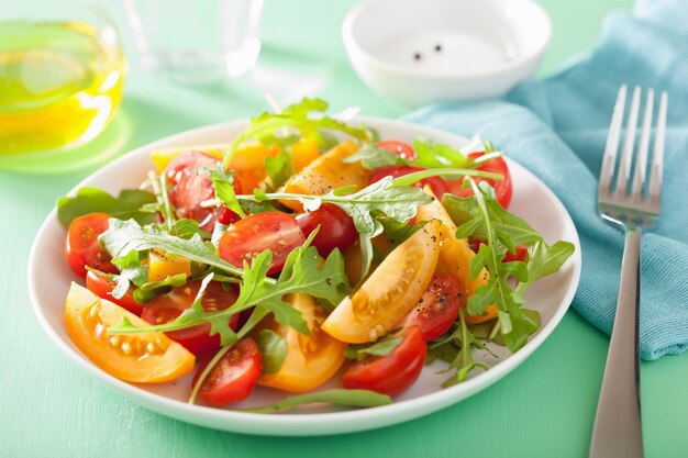 Salada de tomate com rúcula sobre mesa verde