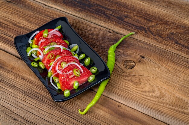 Salada de tomate e pimenta em fundo de madeira