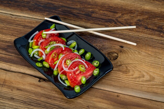 Salada de tomate e pimenta em fundo de madeira