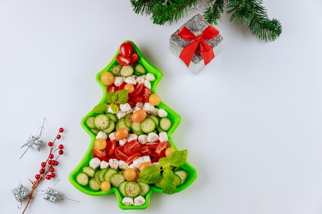 Salada de vegetais de forma de árvore de natal de ano novo com decoração.