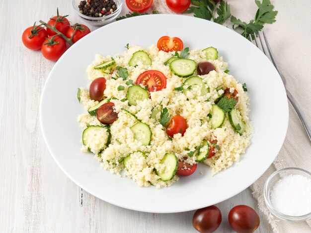 Salada de vegetais frescos da dieta com cuscuz, tomates, pepinos, salsa,