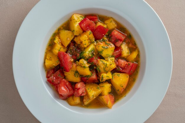 Salada de verão colorida com tomate e pêssego, temperada com molho de azeite, suco de limão e vinagre balsâmico, close-up