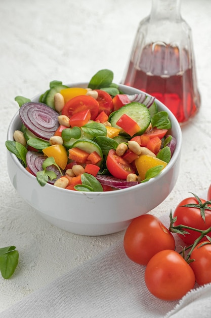 Salada de verão com tomate cereja, pepino, pimentão, cebola, manjericão e amendoim.