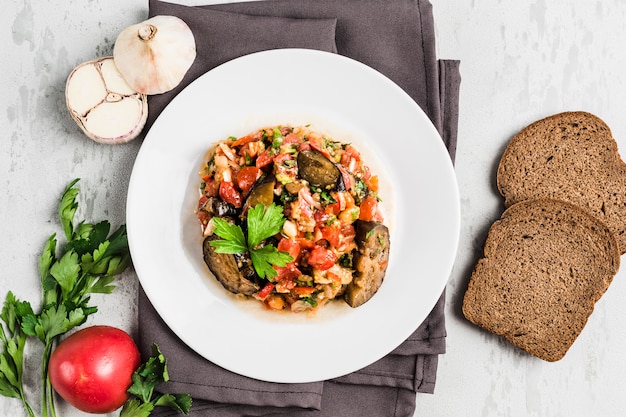 Salada de Verão de berinjela e tomate em um prato branco