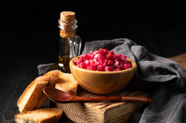 Foto salada de vinagrete em um copo de madeira em um fundo escuro