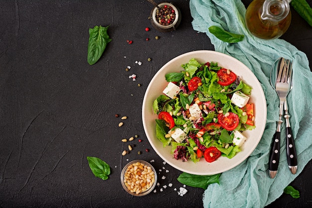 Salada dietética com tomate, queijo feta, alface, espinafre e pinhões.