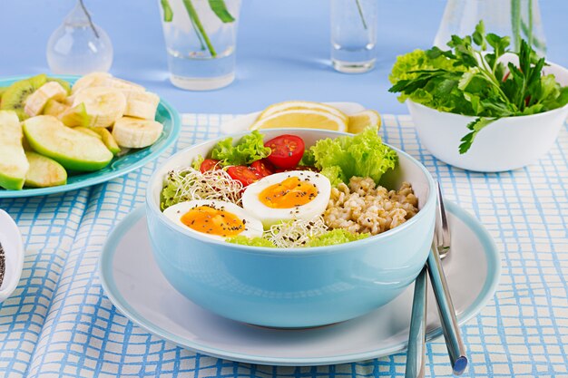 Salada fresca com aveia, tomate, alface, microgreens e ovo cozido e prato de frutas