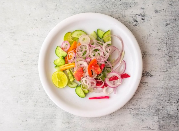 Salada fresca com cebola pepino cenoura limão e tomate servido em um prato isolado na vista superior de fundo de comida indiana e paquistanesa desi