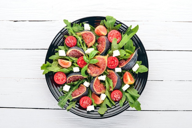 Salada fresca com figos rúcula deixa tomate cereja e queijo feta Espaço livre para texto Vista superior