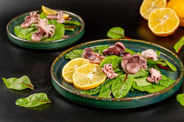 Salada fresca com folhas de beterraba de polvo em conserva e fundo escuro de limão