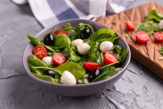 Salada fresca com queijo mussarela tomate espinafre closeup comida saudável