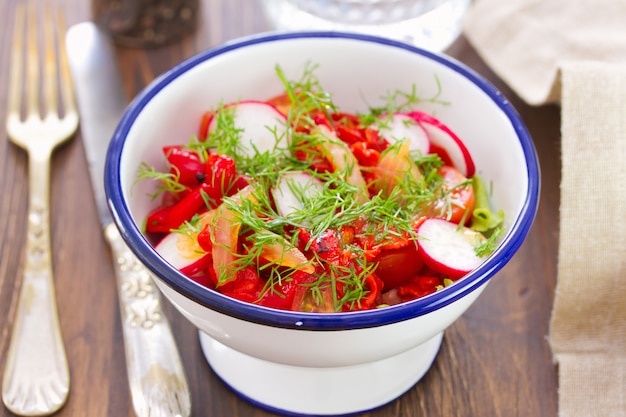 Salada fresca com rabanete na tigela branca na mesa de madeira