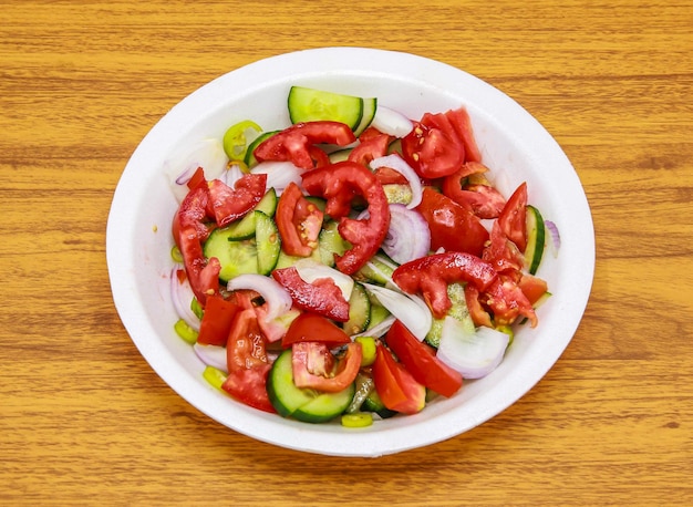 Salada fresca com tomate pepino cebola e pimentão verde servido em prato isolado na mesa vista superior de comida picante indiana e paquistanesa