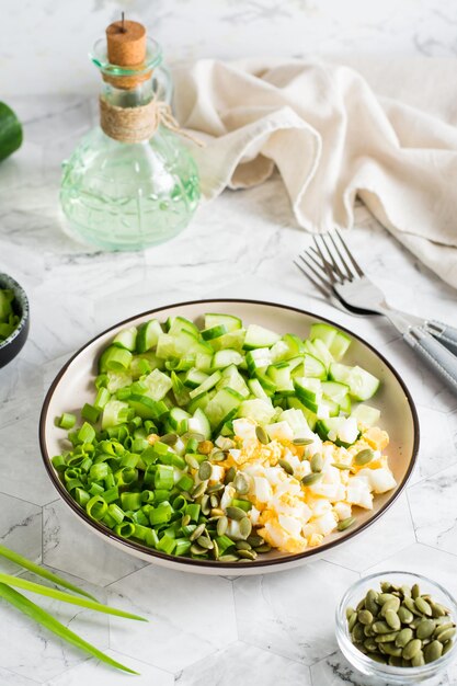 Salada fresca de ovo cozido de pepino e cebola verde em um prato Dieta cetogênica Vista vertical