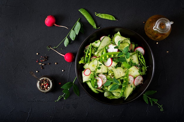 Salada fresca de pepino, rabanete, ervilhas e ervas. Postura plana. Vista do topo