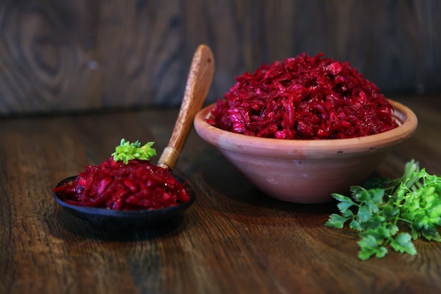 Salada fresca de repolho roxo e cenoura, salada vegan - comida caseira saborosa e deliciosa em um fundo de madeira rústico, prato de coquetel de vitamina para refeição. cebola verde ou mistura de alho