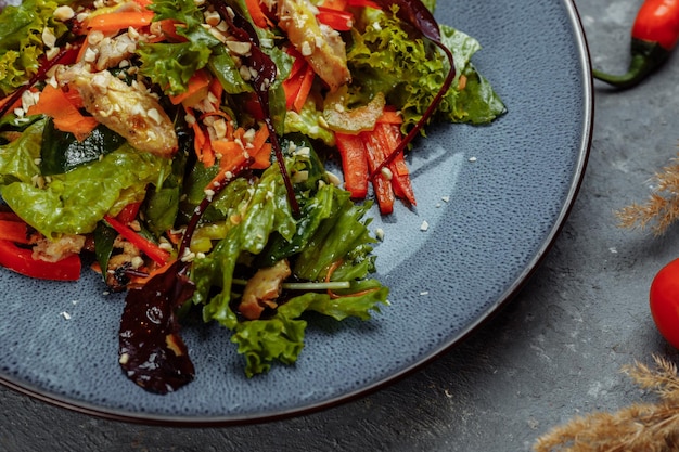 Salada fresca orgânica saudável com tomate, pimentão e frango Masala Peitos de frango grelhado e legumes frescos em prato