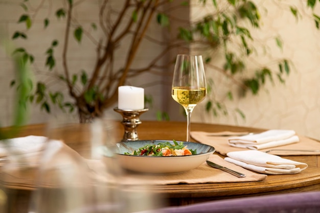 Salada fresca servida com um copo de vinho servido mesa